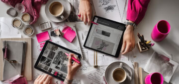 Zwei Designerinnen arbeiten gemeinsam im Branding-Prozess: kreative Zusammenarbeit mit Skizzen, Tablets, Farbmustern und Kaffeepause.